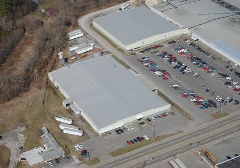 Aerial view of industrial buildings and parking.